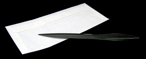 Purisme carbon fiber letter opener on envelope black background