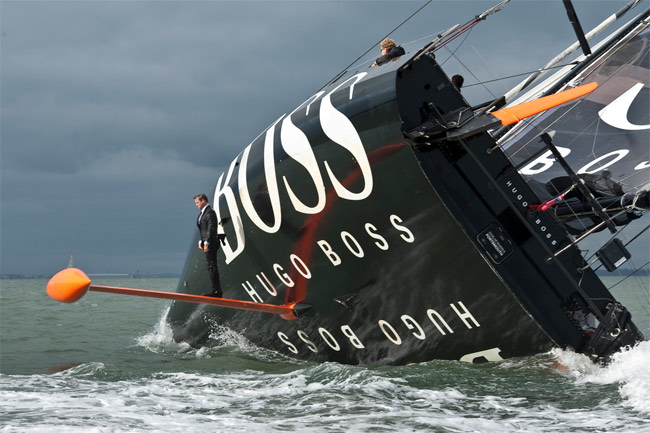 Alex Thompson standing on the keel of the Hugo Boss yacht